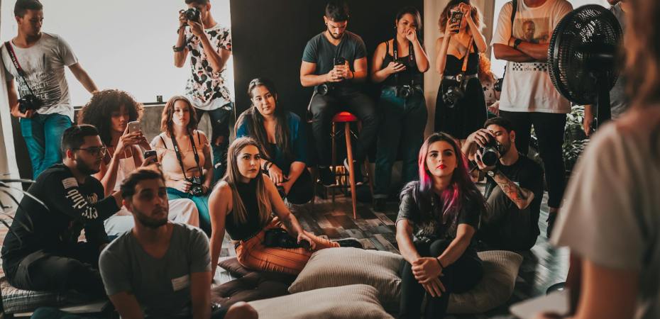 young diverse people gathering in studio and listening to speaker