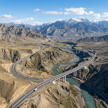 Highways and bridges crossing a turquoise river in a mountain valley
