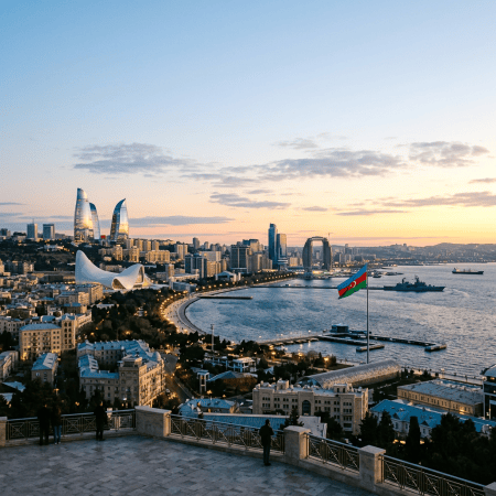 Baku skyline and waterfront with Azerbaijan flag at sunset